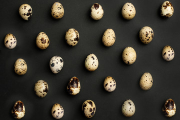 Quail eggs close-up on a black background.Holiday easter, minimalistic black composition