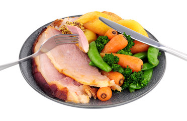 Roast gammon and vegetable meal isolated on a white background