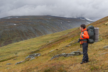 female hiker witt backpack at Kungsleden trail admiring nature of Sarek