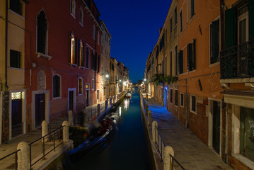 Fototapeta na wymiar Canale illuminato di sera vicino canal grande, con case colorate a Venezia, Italia