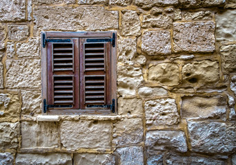 Old window in a stone wall. Malta.