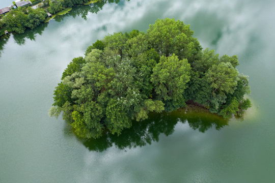 Blick von oben auf eine bewaldete kleine Insel in einem Baggersee im Hessischen Ried/Deutschland