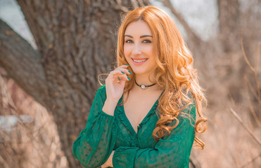 Redhead romantic girl in green blouse, boho style, concept of hair, wig