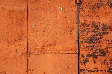Metallic rusty orange wall with peeling paint. Background texture