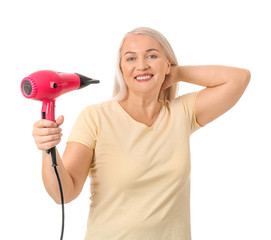 Beautiful mature woman with hair dryer on white background