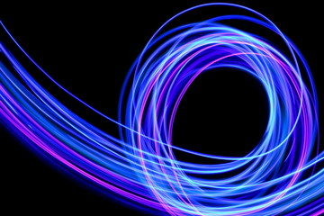 Light painting photography, long exposure photo of purple and blue streaks of vibrant color against...