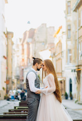 Sweet newlyweds standing facing each other against the backdrop of morning city