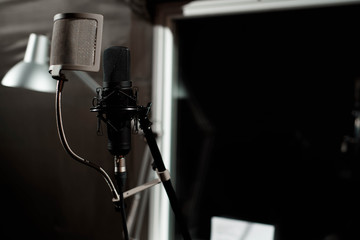 Black vocal microphone is stand in sound recording studio room u