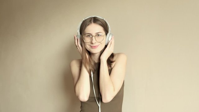 young millennial woman in glasses listening to music while shooting herself on the phone
