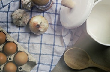 Ingredient in the kitchen with sunlight from the window. Close up view of ingredients of fried egg and vintage pot. Eggs, Onion, Garlic and pepper for cooking. 