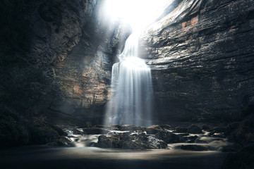 Waterfall in a cave in a mysterious environment. Tourism in Spain, Catalonia, Barcelona, Osona,...