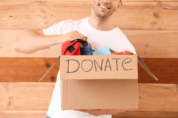 Volunteer with donations for orphans on wooden background