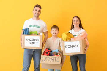 Volunteers with donations for orphans on color background