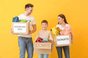 Volunteers with donations for orphans on color background