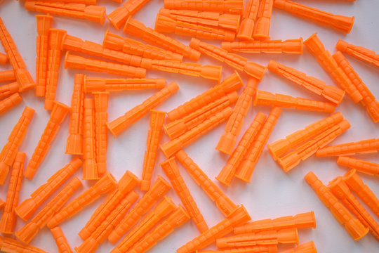 Plastic Wall Plow For backdrop. Orange color on a white background. Concept of building hardware anchor.