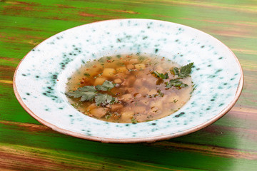 Buckwheat soup with porcini mushrooms. On a colored wooden background. Vegetarian dish.