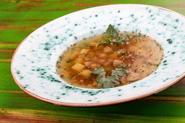 Buckwheat soup with porcini mushrooms. On a colored wooden background. Vegetarian dish.
