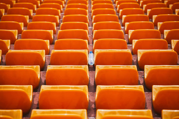 the prospect of empty orange tribunes with a bottle of water lying in the middle