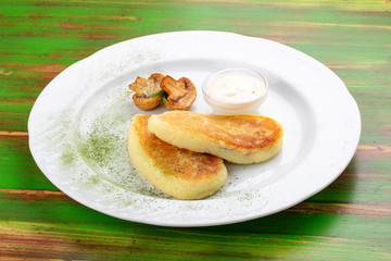 Potato zrazy with sour cream. On a colored wooden background. Vegetarian dish.