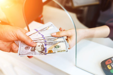 man changes money in a currency exchange, a large sum of dollars, an increase in the exchange rate