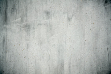 Textured old grunge gray metal background covered in peeling paint with light dark vignette in the corners.