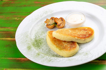 Potato zrazy with sour cream. On a colored wooden background. Vegetarian dish.