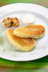 Potato zrazy with sour cream. On a colored wooden background. Vegetarian dish.