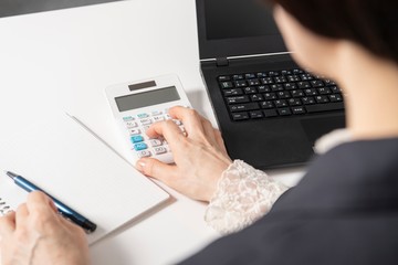 電卓で計算をする女性