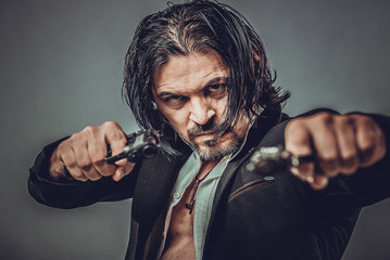 sexy muscular body model portrait of a young man holding a gun in his hands