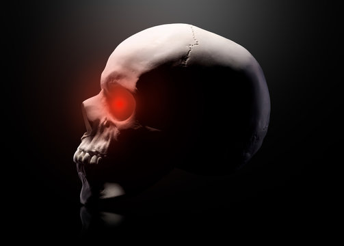 Model of the human skull with red eyes isolated on black background