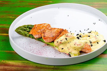 Salmon on asparagus with turmeric and shrimp sauce.