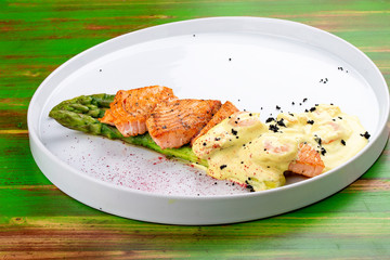 Salmon on asparagus with turmeric and shrimp sauce.