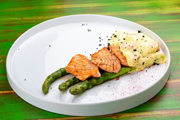 Salmon on asparagus with turmeric and shrimp sauce.