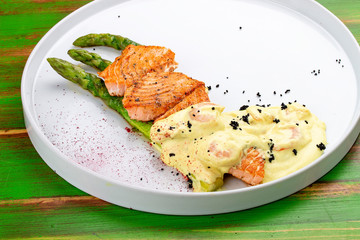 Salmon on asparagus with turmeric and shrimp sauce.