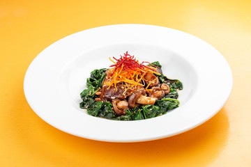 Fried shiitake mushrooms with spinach. Vegetarian dish.