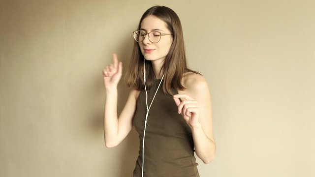 young millennial woman in glasses listening to music while shooting herself on the phone