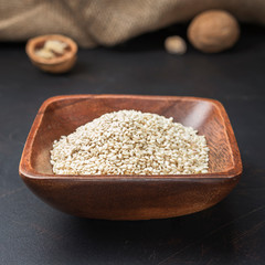 spices seasonings and grains on a square wooden bowl on a dark background and burlap