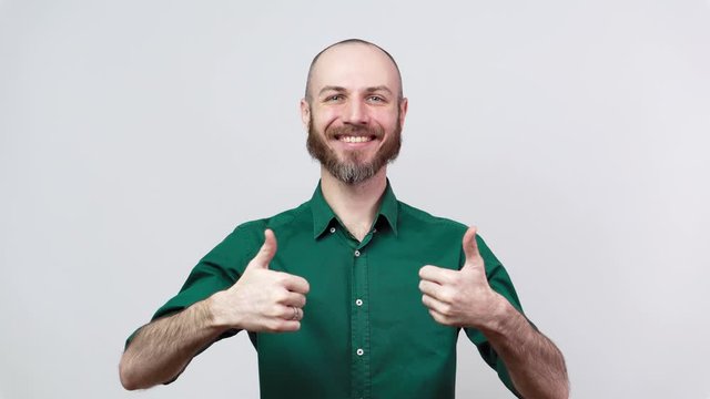Happy bearded man wearing shirt showing thumbs up sign over white background. Good job, very well.