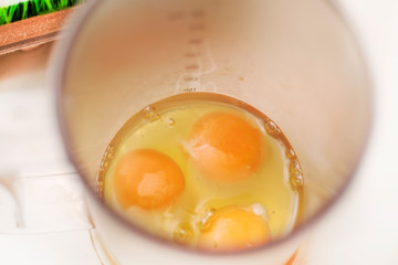 Raw eggs in a blender bowl on table.