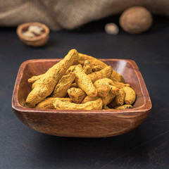 spices seasonings and grains on a square wooden bowl on a dark background and burlap