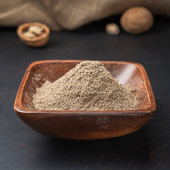 spices seasonings and grains on a square wooden bowl on a dark background and burlap