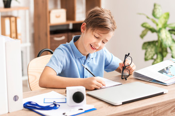 Naklejka premium Little journalist working in office