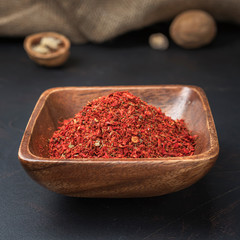 spices seasonings and grains on a square wooden bowl on a dark background and burlap