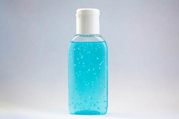 A bottle of hand sanitizer gel. Hand hygiene as coronavirus protection. Antivirus and antibacterial product. Blue liquid with white round granules. Copy space for text