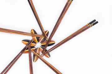 Isolated of Wooden chopsticks on chopstick rest arrange in flower shape