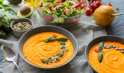 Bowl of vegetarian pumpkin carrot soup served with seeds