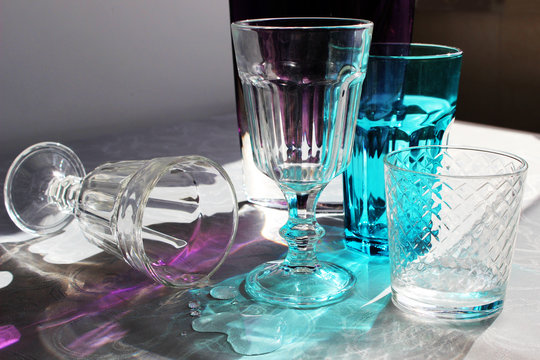  multi-colored glasses on a table in the rays of sunlight