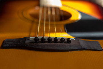Close up acoustic guitar bridge pin in the sun