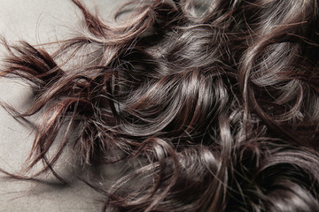 Curly female hair on dark background, closeup