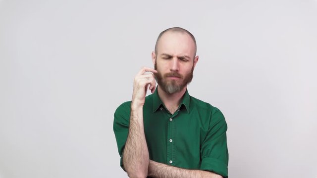 Portrait of serious bearded man thinking or remembering, isolated over white background. Concept of emotions.